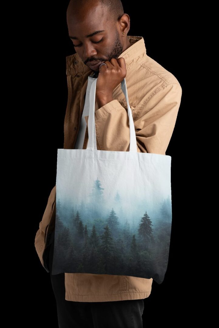 Man holding an all-over-print tote bag by Hoodie Lab