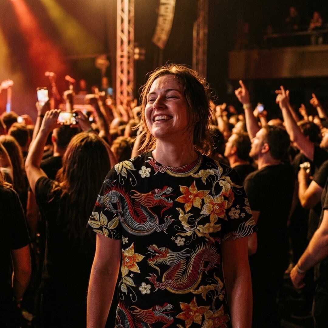 Woman laughing in a gig crowd wearing an ancient dragon all-over-print t-shirt